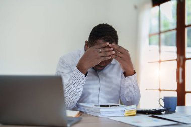 Stresli Amerikalı Yanmış Afrikalı iş adamı evrak işleriyle uğraşıyor. Migren saldırısı, serbest çalışma, evden çalışma..