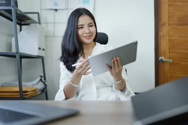 business owner or Asian female marketers are using tablet computer in office work.