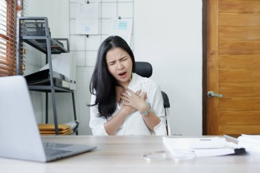 Genç Asyalı kadın temsilcinin portresi iş yerinde uzun süre oturmaktan akut göğüs ağrısı gösteriyor. Yüksek kalite fotoğraf