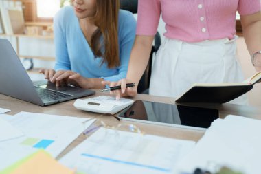 Şirket toplantıları sırasında planlanan yatırım projeleriyle ilgili iş raporlarını analiz eden mali analistler pazarlama planı, bilgisayarlar ve hesap makineleriyle başarılı bir takım çalışması sergilediler..