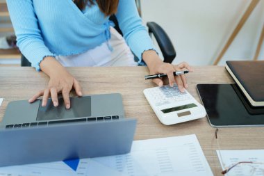 Muhasebeciler ve Asyalı denetçiler vergi bütçelerini gözden geçirmek için hesap makineleri ve bilgisayarlar kullanarak vergi dairesine bilgi gönderiyorlar.