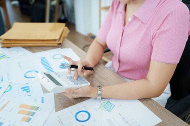 Finansal, Planlama, Pazarlama ve Muhasebe, Asyalı çalışanın portresi Mali durumları kontrol eden Belgeler ve hesap makineleri kullanarak..