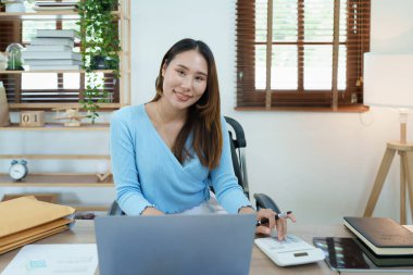 Muhasebeciler ve Asyalı denetçiler vergi bütçelerini gözden geçirmek için hesap makineleri ve bilgisayarlar kullanarak vergi dairesine bilgi gönderiyorlar.