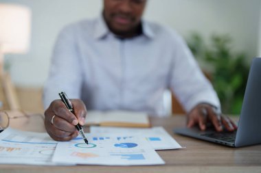 Orta yaşlı Amerikalı Afrikalı adam bilgisayarını kullanarak finansal belge, vergi, döviz, muhasebe ve mali danışman üzerinde çalışıyor. denetleyici veya denetim kavramları.