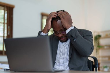 Stresli Amerikalı Yanmış Afrikalı iş adamı evrak işleriyle uğraşıyor. Migren saldırısı, serbest çalışma, evden çalışma..