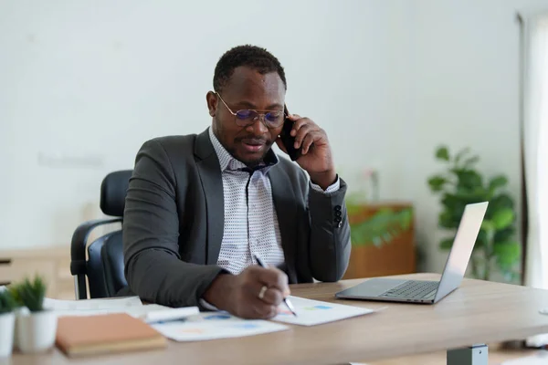 Мужчина Среднего Возраста Афроамериканец Использующий Смартфон Мобильный Ноутбук Планированием Работы — стоковое фото