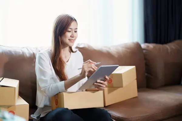 由独立的年轻亚洲女性在线销售商创办的小企业创业者正在使用平板电脑 并接受订单包装产品 以提供给客户 中小型企业交付概念 — 图库照片