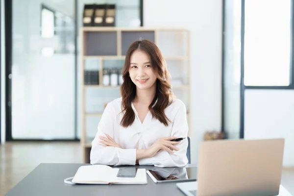 一位女企业主的画像 面带微笑 她用电脑和财务预算文件成功地投资了她的生意 — 图库照片