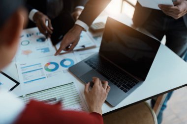 Toplantının mali raporunda durumu analiz etmek ve tartışmak için bilgisayar bilgisayarı, tablet, hesap makinesi ve çalışma odasındaki belgeleri kullanarak takım danışmanı toplantısı düzenlendi.