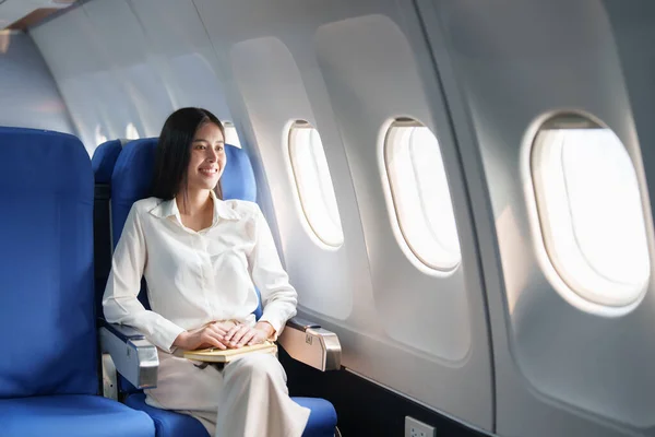 アジアの魅力的なビジネス女性の乗客はビジネスクラスの豪華な飛行機に座ってリラックスしながら旅行のコンセプト — ストック写真