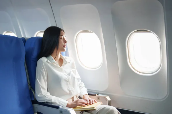 Asian attractive business woman passenger sitting on business class luxury plane while relax while travel concept.