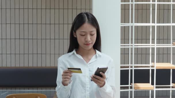 Junge Schöne Asiatin Mit Smartphone Handy Und Kreditkarte Waren Bezahlen — Stockvideo