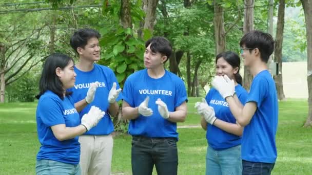 さまざまな国籍のボランティアが連帯を示し 個人的な時間を寄付し 公共公園の汚染を減らすためにリサイクルのためのプラスチック廃棄物を収集するために黒いゴミ袋を持っています — ストック動画