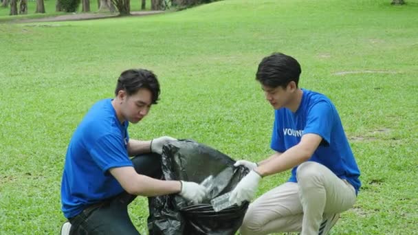 多族裔志愿者捐出他们的时间 拿着黑色垃圾袋收集塑料废物 供回收利用 以减少公园内的污染 高质量的4K镜头 — 图库视频影像