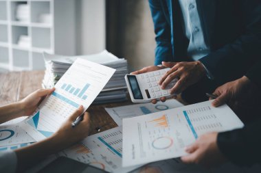 Muhasebeci mali durumu kontrol ediyor ya da vergi beyannamesi için hesap makinesi geliri ile sayıyor, iş kadını ofiste iş arkadaşı ile oturup tartışıyor. Denetim kavramı.