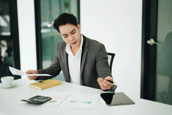 stock image businessman or accountant working on calculator and laptop computer to calculate business data during using accountancy document at office