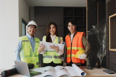 Evler ve binalar için mimari ve mühendislik tasarımı hakkında kağıt işleri ve zemin planı çizimlerinin maliyet tahmini için çok ırklı mühendis beyin fırtınası ve ölçümü.