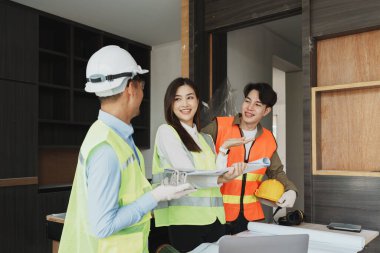 Evler ve binalar için mimari ve mühendislik tasarımı hakkında kağıt işleri ve zemin planı çizimlerinin maliyet tahmini için çok ırklı mühendis beyin fırtınası ve ölçümü.