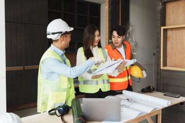 Evler ve binalar için mimari ve mühendislik tasarımı hakkında kağıt işleri ve zemin planı çizimlerinin maliyet tahmini için çok ırklı mühendis beyin fırtınası ve ölçümü.