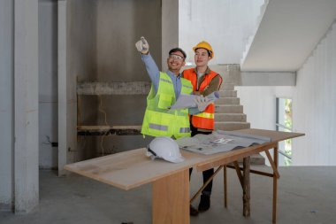 Çok ırklı mühendis, bina ve evler için mimari ve mühendislik tasarımı hakkında planlar ve kat planı çizimlerinin maliyet tahmini için beyin fırtınası ve ölçümlemesi.