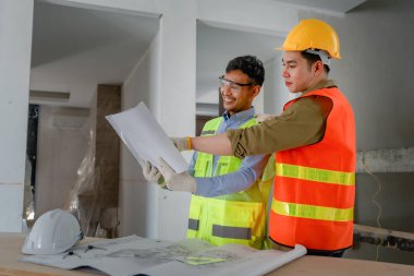 Çok ırklı mühendis, bina ve evler için mimari ve mühendislik tasarımı hakkında planlar ve kat planı çizimlerinin maliyet tahmini için beyin fırtınası ve ölçümlemesi.