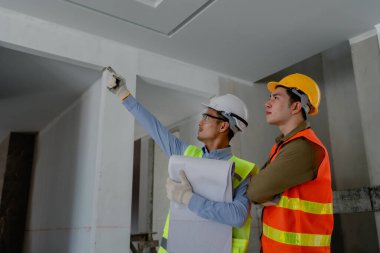 Çok ırklı mühendis, bina ve evler için mimari ve mühendislik tasarımı hakkında planlar ve kat planı çizimlerinin maliyet tahmini için beyin fırtınası ve ölçümlemesi.
