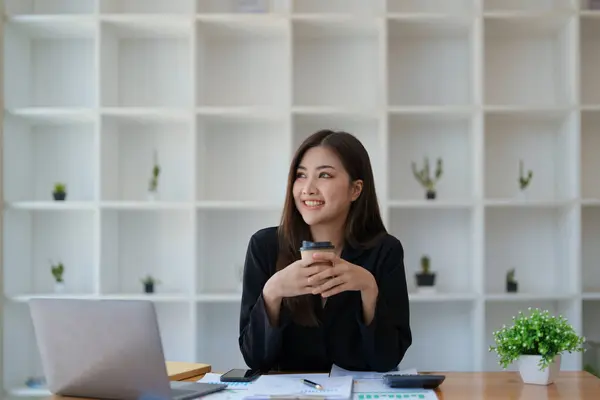 幸せな笑顔を見せる女性経営者の肖像彼は正常に仕事でコンピュータや金融予算の文書を使用して彼女のビジネスを投資しているとして — ストック写真