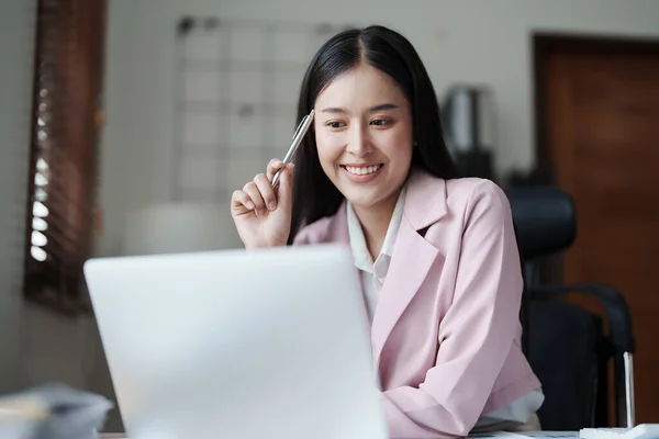 一位女企业主在利用计算机成功地投资于她的生意时 脸上挂着快乐笑容的画像 — 图库照片