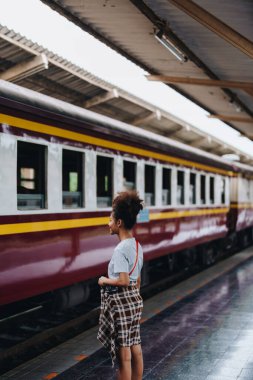 Afro-Amerikan turistler tren istasyonunda yolculuklarını beklerken mutlu yüz ifadeleri sergiliyorlar.