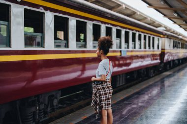 Afro-Amerikan turistler tren istasyonunda yolculuklarını beklerken mutlu yüz ifadeleri sergiliyorlar.