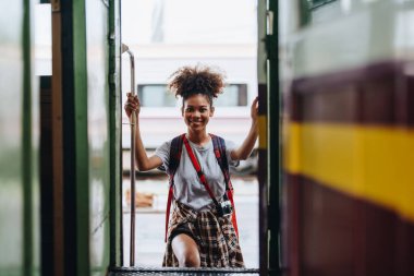 Afro-Amerikan turistler tren istasyonunda yolculuklarını beklerken mutlu yüz ifadeleri sergiliyorlar.