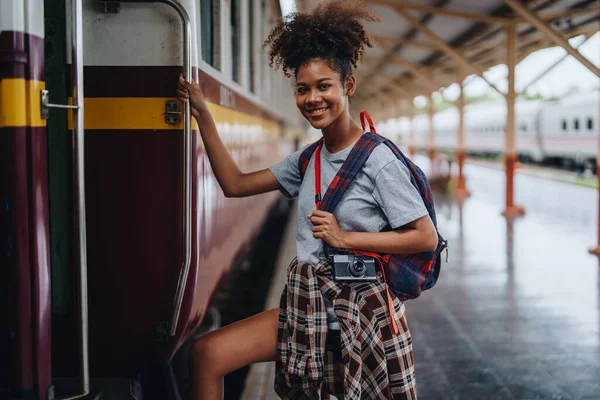 Afro-Amerikan turistler tren istasyonunda yolculuklarını beklerken mutlu yüz ifadeleri sergiliyorlar.