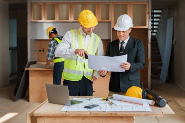 Çok ırklı mühendis, bina ve evler için mimari ve mühendislik tasarımı hakkında planlar ve kat planı çizimlerinin maliyet tahmini için beyin fırtınası ve ölçümlemesi.