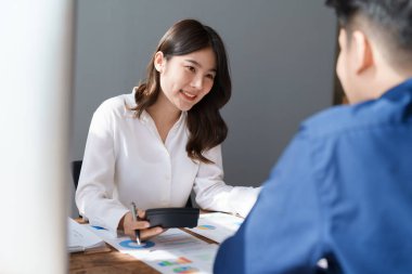 Muhasebeci mali durumu kontrol ediyor ya da vergi beyannamesi için hesap makinesi geliri ile sayıyor, iş kadını ofiste iş arkadaşı ile oturup tartışıyor. Denetim kavramı.