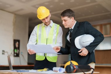 Çok ırklı mühendis, bina ve evler için mimari ve mühendislik tasarımı hakkında planlar ve kat planı çizimlerinin maliyet tahmini için beyin fırtınası ve ölçümlemesi.