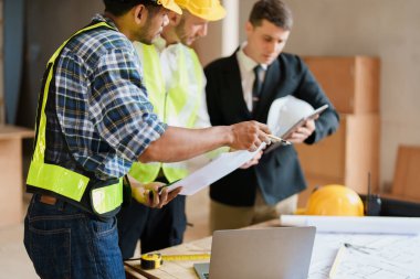 Evler ve binalar için mimari ve mühendislik tasarımı hakkında kağıt işleri ve zemin planı çizimlerinin maliyet tahmini için çok ırklı mühendis beyin fırtınası ve ölçümü.