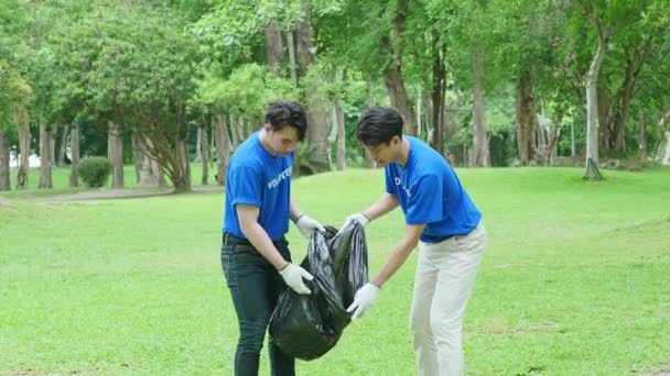 多族裔志愿者捐出他们的时间 拿着黑色垃圾袋收集塑料废物 供回收利用 以减少公园内的污染 高质量的4K镜头 — 图库视频影像