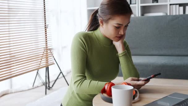 Asiática Jovem Mulher Trabalhando Casa Sentado Seu Telefone Enquanto Descansa — Vídeo de Stock