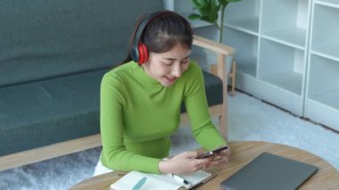 Rahat Asyalı kadın kulaklık takıyor akıllı telefon kullanarak sosyal medyada geziniyor, haberleri kontrol ediyor, müzik dinliyor ya da koltukta oturan mesajları dinliyor. Milenyum bayanı evde vakit geçiriyor. Yüksek kalite