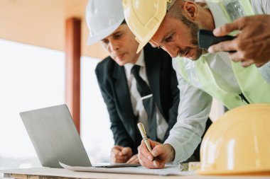 Çok ırklı mühendis, bina ve evler için mimari ve mühendislik tasarımı hakkında planlar ve kat planı çizimlerinin maliyet tahmini için beyin fırtınası ve ölçümlemesi.