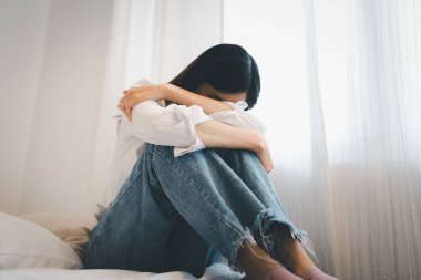 Genç ve çekici Asyalı kadın oturma odasındaki kanepede uzanıyor üzgün hissediyor yorgun ve endişeli zihinsel sağlık, sorunlar ve kırık kalp konsepti yüzünden depresyon geçiriyor.