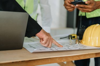 Evler ve binalar için mimari ve mühendislik tasarımı hakkında kağıt işleri ve zemin planı çizimlerinin maliyet tahmini için çok ırklı mühendis beyin fırtınası ve ölçümü.