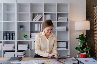 Ofis içinde siyah takım elbiseli bir iş kadını tablet bilgisayar kullanıyor, müşterilerin iletişim kurması için denetleme evrakları, iş adamları kavramı