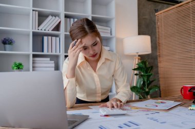 İşletme sahibi, bilgisayar ve finansal tabloları kullanan kadın portresi piyasayı genişletmek için endişe verici bir ifade..