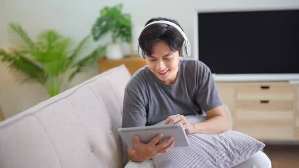 Snygg Asiatisk Man Med Hörlurar Som Lyssnar Musik Och Använder — Stockvideo