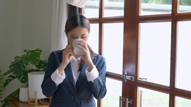 コーヒーを飲みながら座って休んでいる若いアジアのビジネス女性 高品質4K映像 — ストック動画