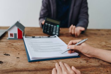 Teminat, mortgage, sözleşme, sözleşme, kontrat, emlakçı ya da banka memuru elinde hesap makinesi olan bir müşteri ile anlaşma imzalamadan önce bir ev satın almak için teklif sunar..