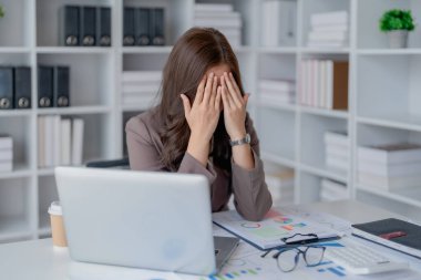 Sme işletme sahibi, bilgisayar ve finansal tabloları kullanan kadın, piyasanın genişletilmesi konusunda endişeli ifade, iş dünyasına yatırım yapma yeteneğini artırmak için.