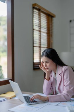 İşletme sahibi, bilgisayar ve finansal tabloları kullanan kadın portresi piyasayı genişletmek için endişe verici bir ifade..