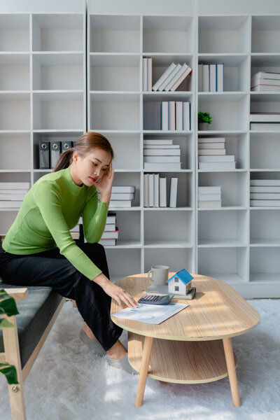 young women sad lady people sit sofa couch at home think hard worry in tax expense saving issue past due loan 